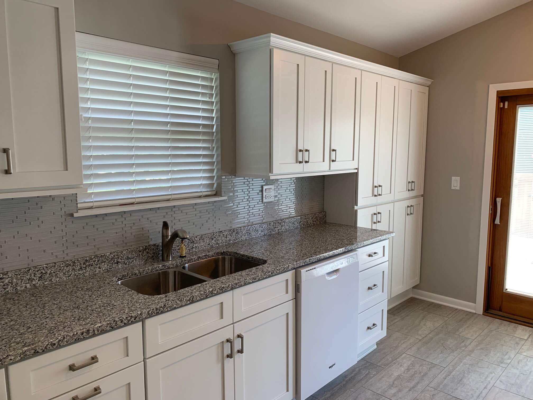 Backyard patio with a wooden pergola, ceiling fan, and built-in outdoor kitchen.