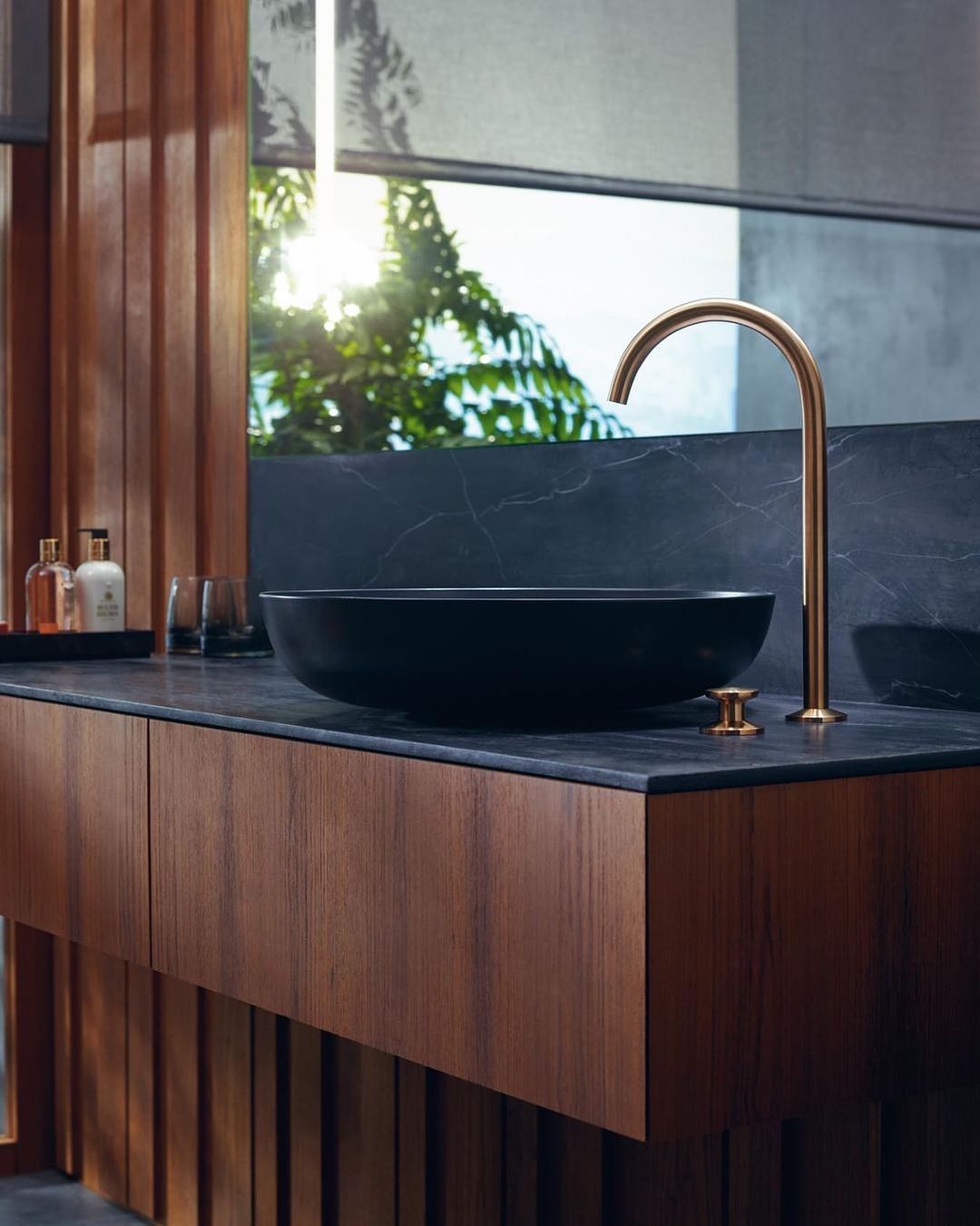 Lavatório preto com torneira alta dourada AXOR One