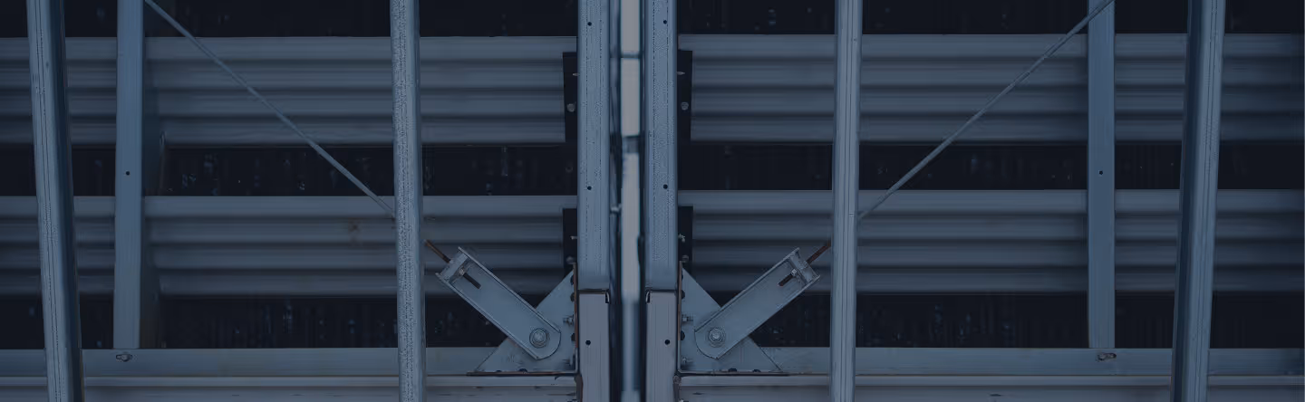 Close-up of symmetrical metal beams and braces forming a structural industrial framework.