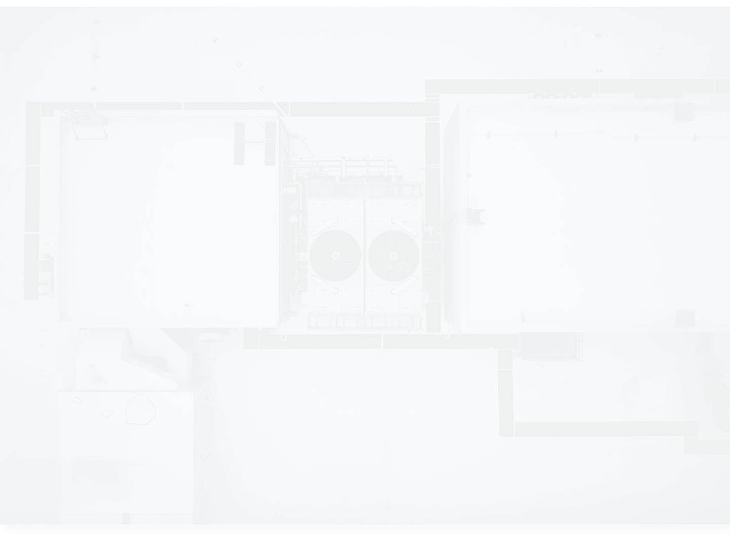 Aerial view of building rooftops featuring large ventilation units and rectangular structures.
