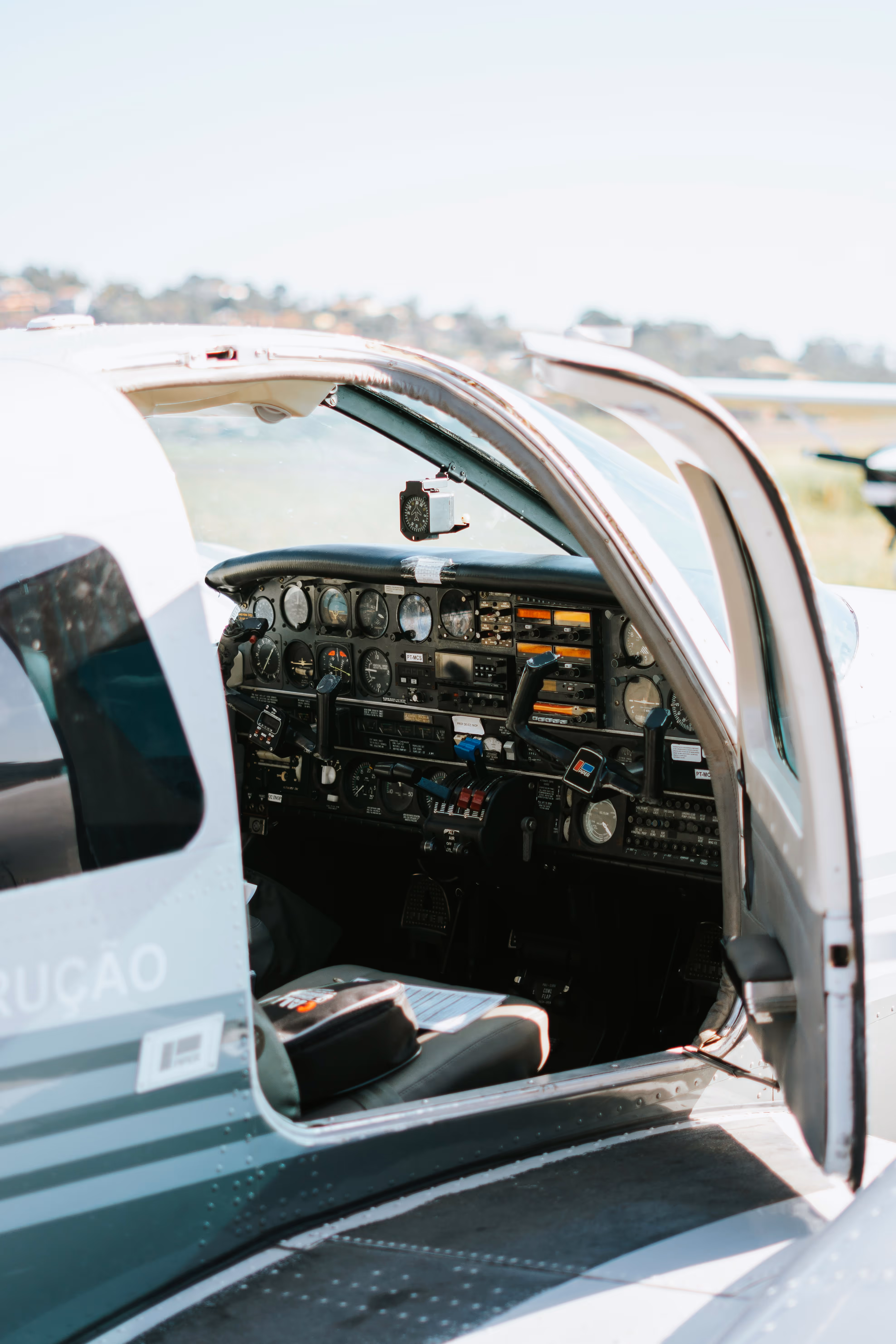 Open cockpit of a small airplane showing detailed flight instruments and controls.