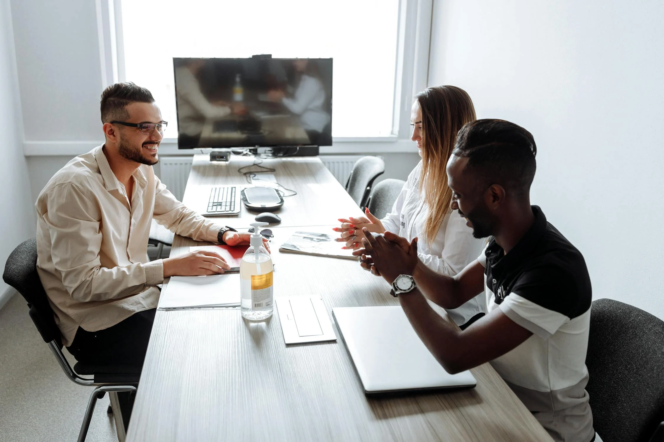 team members sitting together at a tamble with monitor 