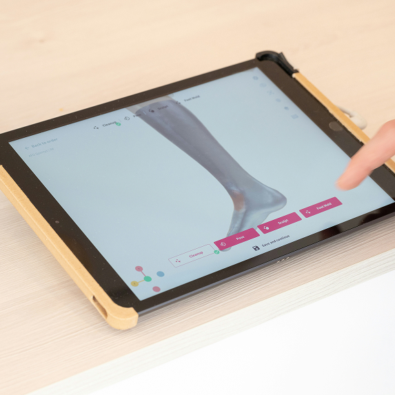 Tablet screen showing a 3D medical image of a human lower leg with menu options for editing and analyzing the image.