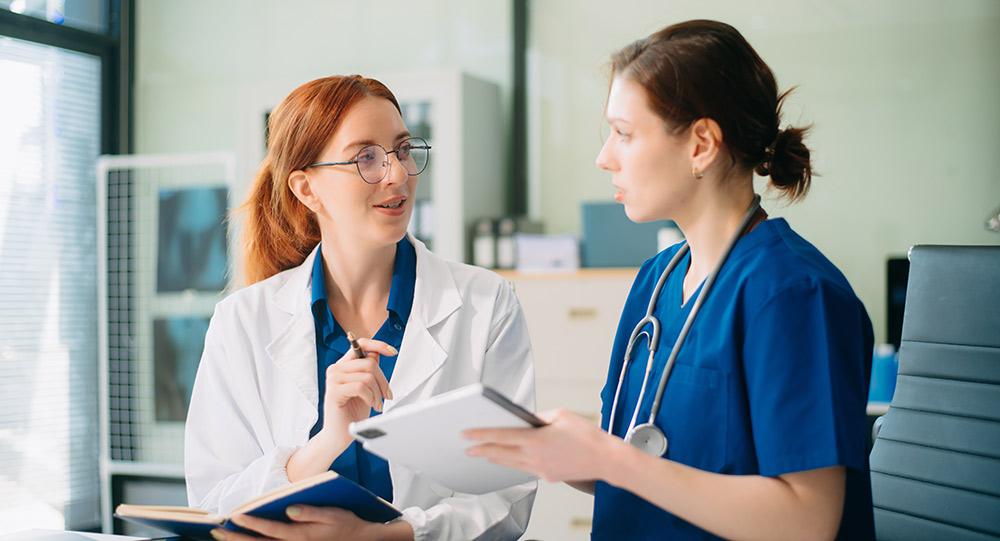 Cosmetic Surgeon looking at tablet with nurse