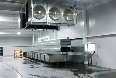 Equipos industriales de enfriamiento y transporte en un gran espacio interior limpio y bien iluminado.