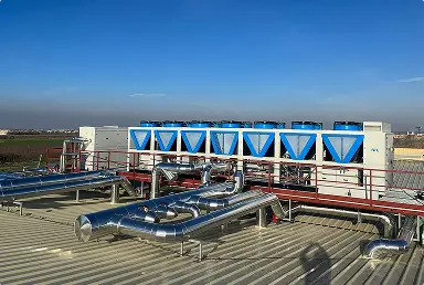 Equipos de aire acondicionado instalados en el techo de un edificio bajo un cielo azul claro.