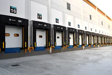 Andén de carga y descarga numerado de un almacén con multiple puertas alineadas.
