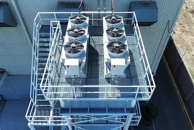 Vista aérea de unidad de ventiladores industriales sobre estructura metálica en edificio industrial.