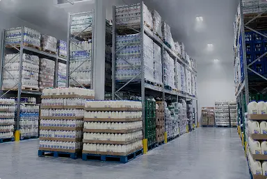 Pasillos amplios de un almacén con estantes llenos de productos lácteos en envases plásticos y cartones.