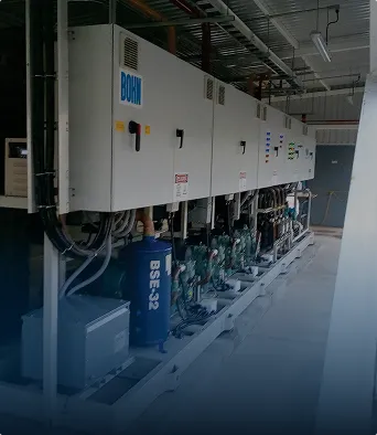 Sala con equipos industriales grandes y paneles de control montados en la pared.