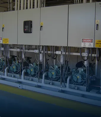 Paneles eléctricos blancos con motores industriales conectados en fila en un espacio industrial.