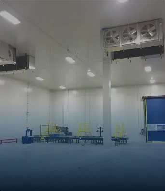 Interior amplio y limpio de un almacén o fábrica con ventiladores industriales y equipo metálico.