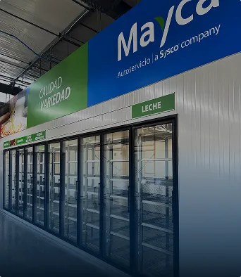 Pasillo de supermercado con vitrinas vacías y señalización verde que indica productos lácteos.