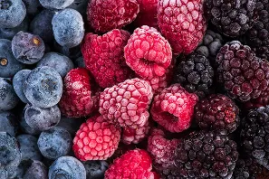 Arándanos, frambuesas y moras congeladas mezcladas en un primer plano.