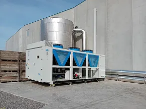 Unidad de aire acondicionado industrial blanca con filtración azul exterior en un edificio industrial.