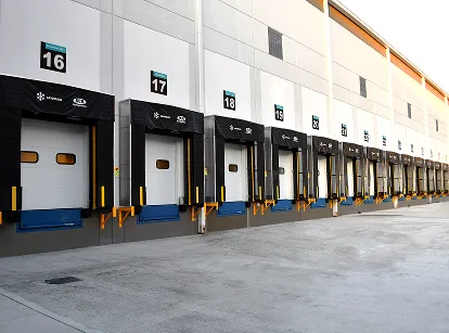 Puertas de carga numeradas en un almacén industrial alineadas con rampas para camiones.