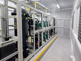 Interior de una sala con equipos industriales de refrigeración en estructura metálica blanca.