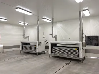 Interior de cuarto blanco con dos congeladores industriales de placas y tuberías.