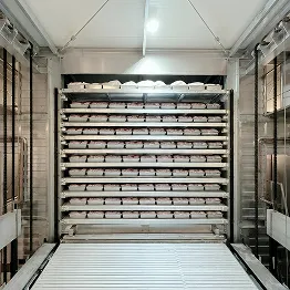 Interior of a large freezer with multiple shelves filled with stacks of carton boxes.