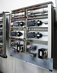 Cuadro eléctrico industrial con cables, interruptores y componentes montados en panel metálico.