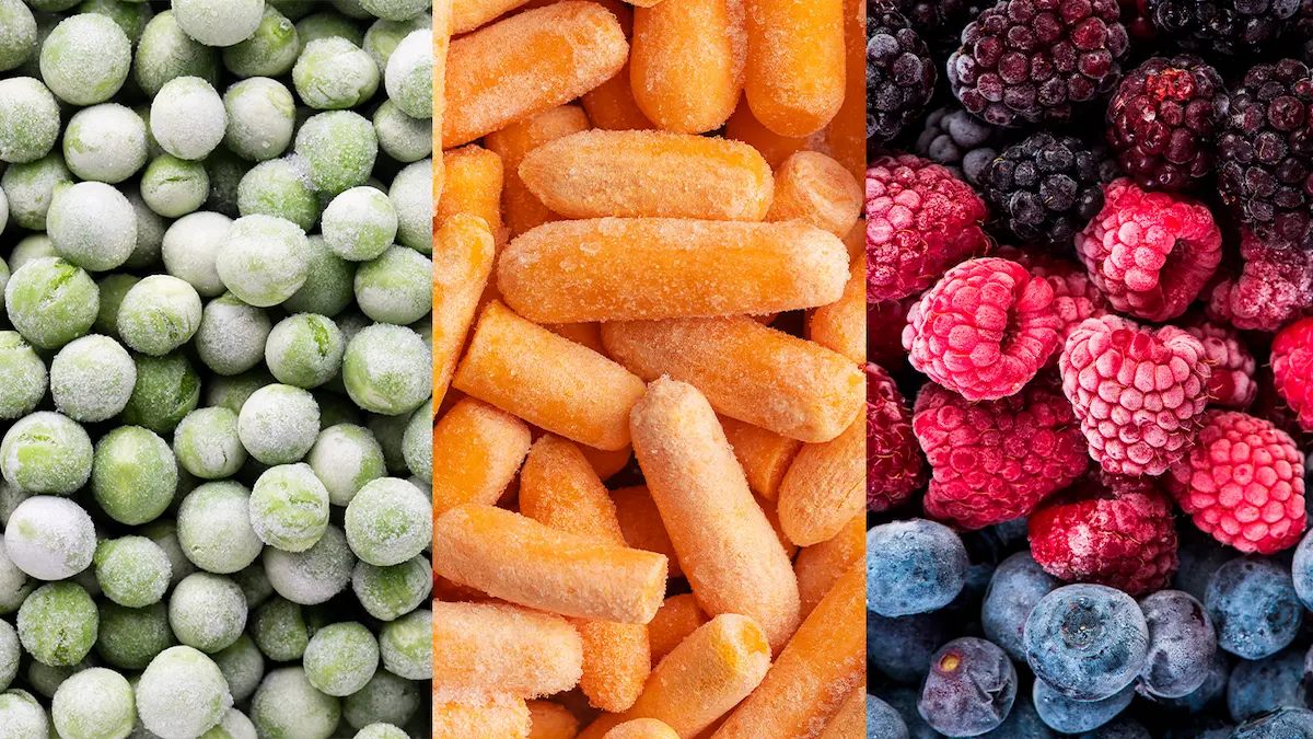Guisantes, mini zanahorias y frutos rojos congelados con escarcha visible.