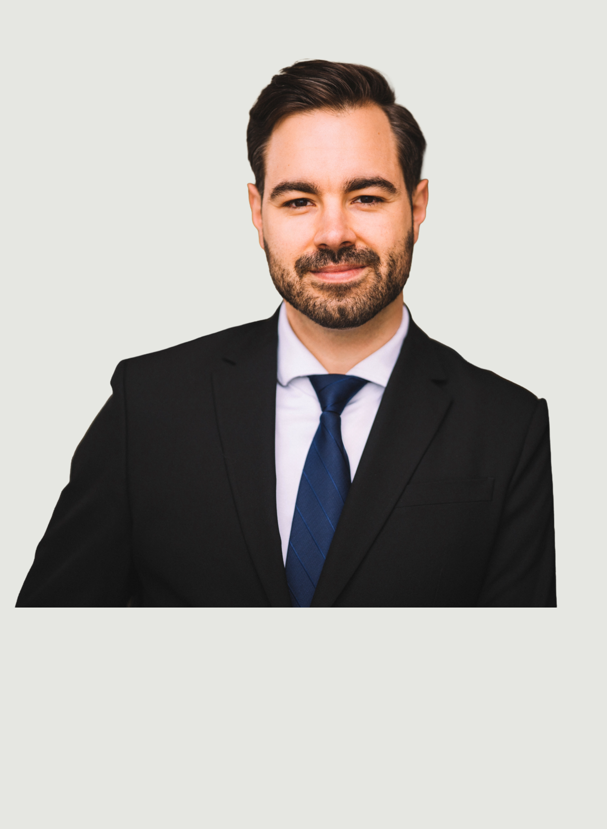 Gut aussehender Mann mit dunklem Haar, Bart und blauer Krawatte, der schwarzen Anzug trägt.