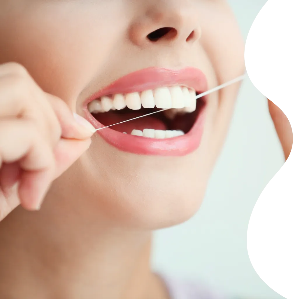Close-up of a person flossing their teeth with dental floss.