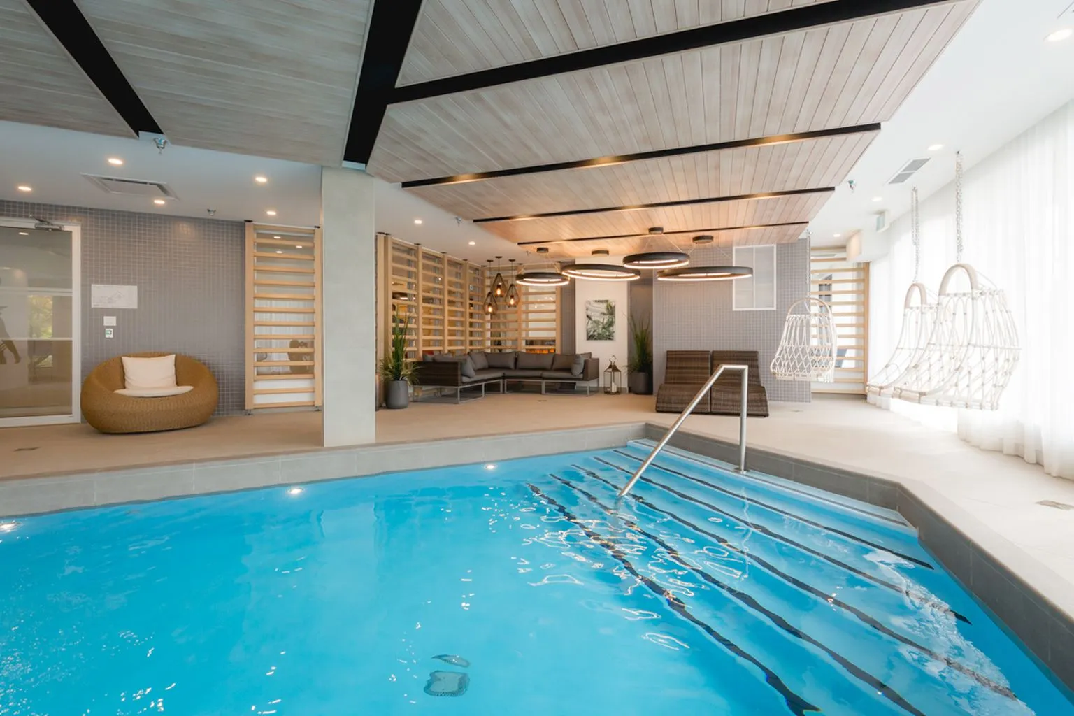 The indoor pool at Mostra Longueuil, with its wood ceiling and hanging chairs