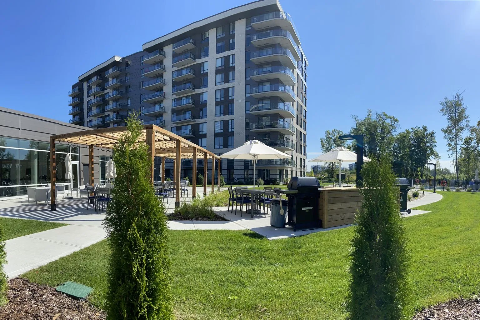 Pavillon extérieur de Mostra Mascouche entouré de pelouse et d’arbres