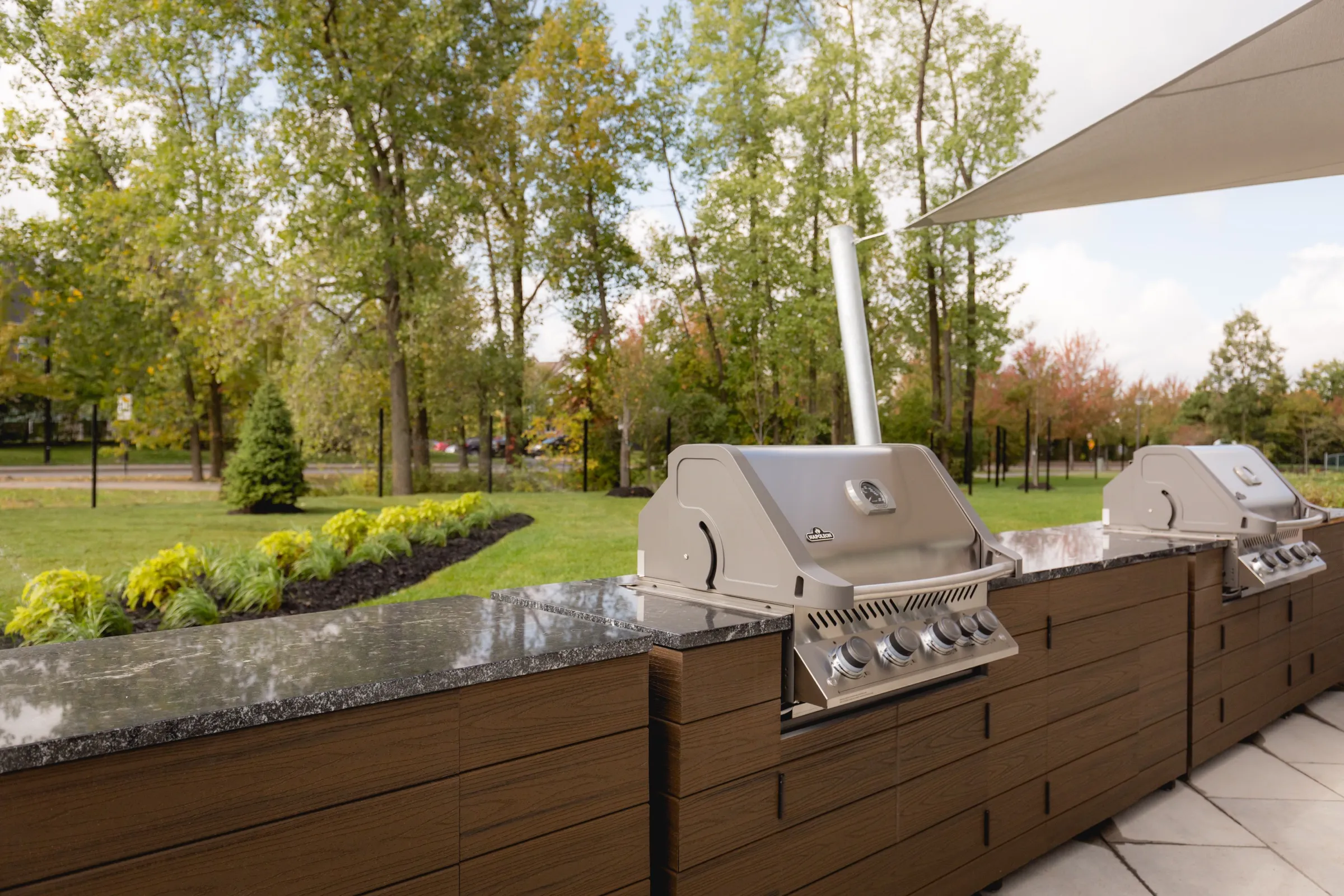 Terrasse extérieure de Mostra Longueuil avec BBQ et espace vert