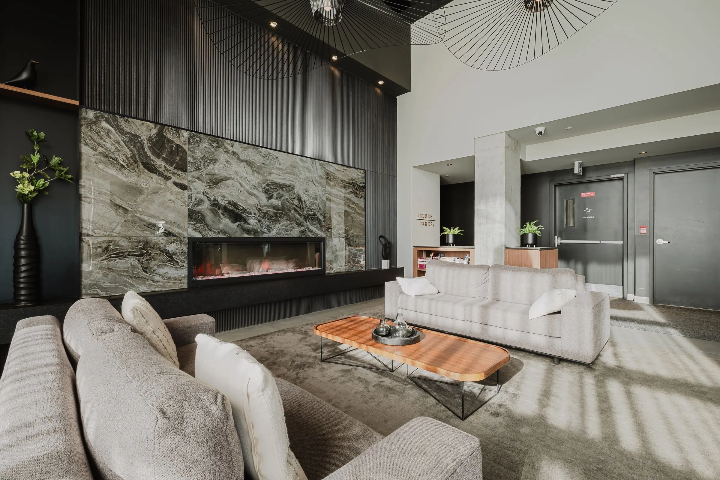 Lounge de Mostra Newman avec foyer, mur de pierre et grands canapés