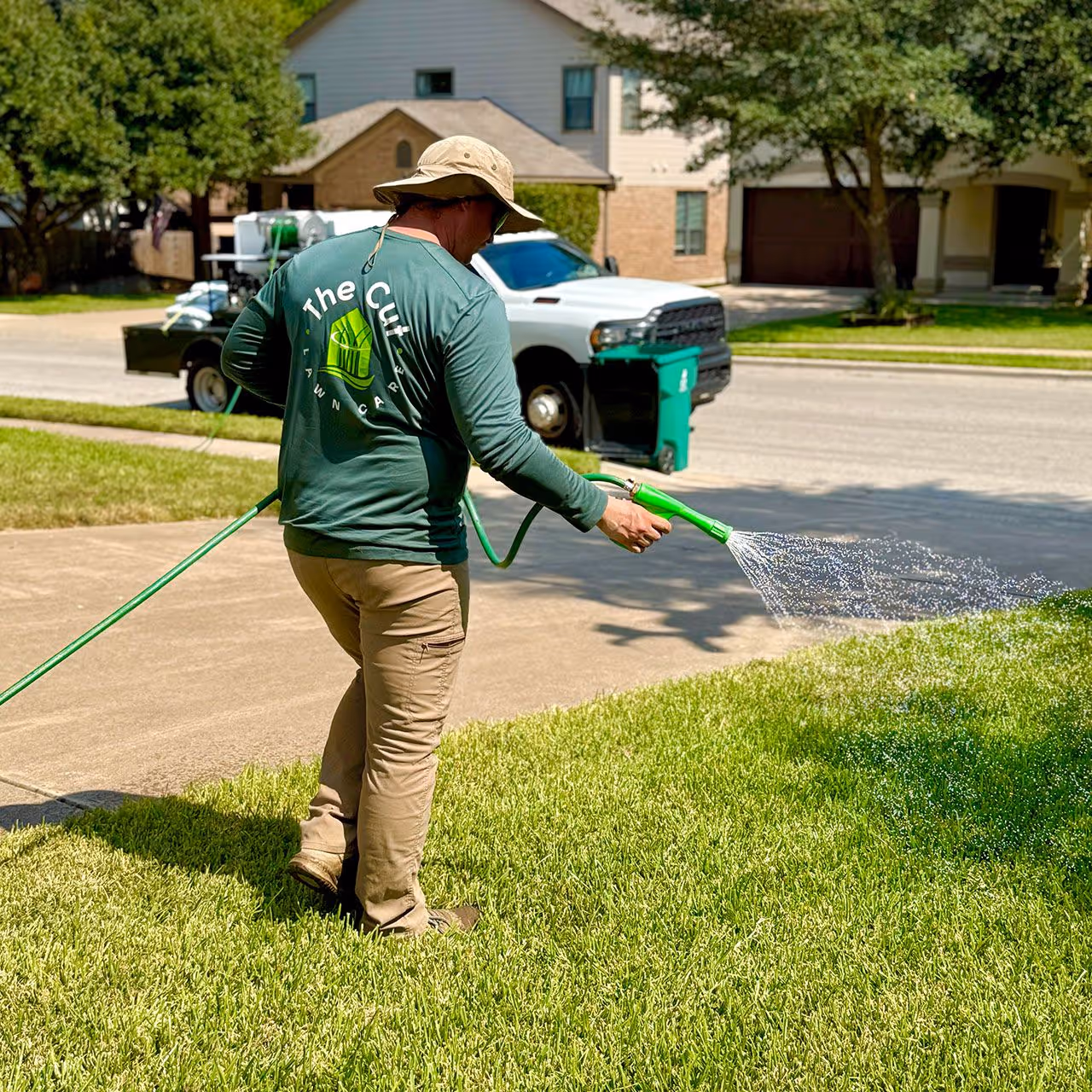 Lawn technician applying weed control on residential property