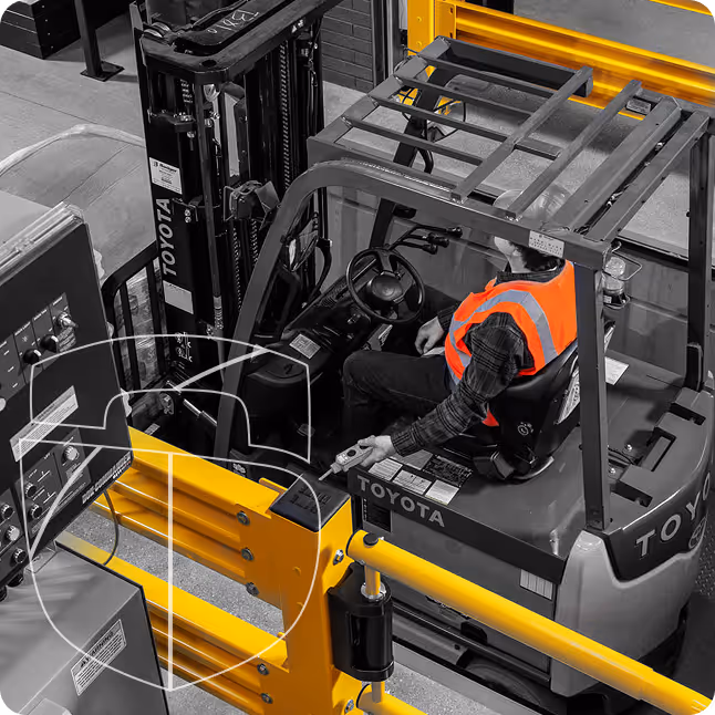 Opérateur sur un chariot élévateur Toyota avec un gilet de sécurité orange dans un entrepôt industriel.