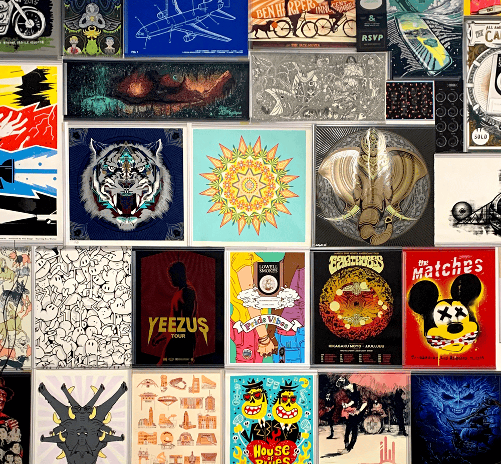 Wall display of various colorful album and poster artworks including a roaring tiger, geometric pattern, elephant head, and multiple band and tour designs.