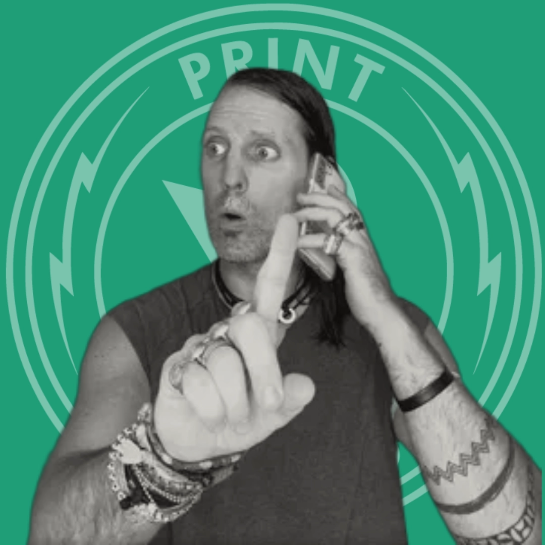 Man with tattoos and bracelets holding a phone to his ear and raising his index finger with a surprised expression.