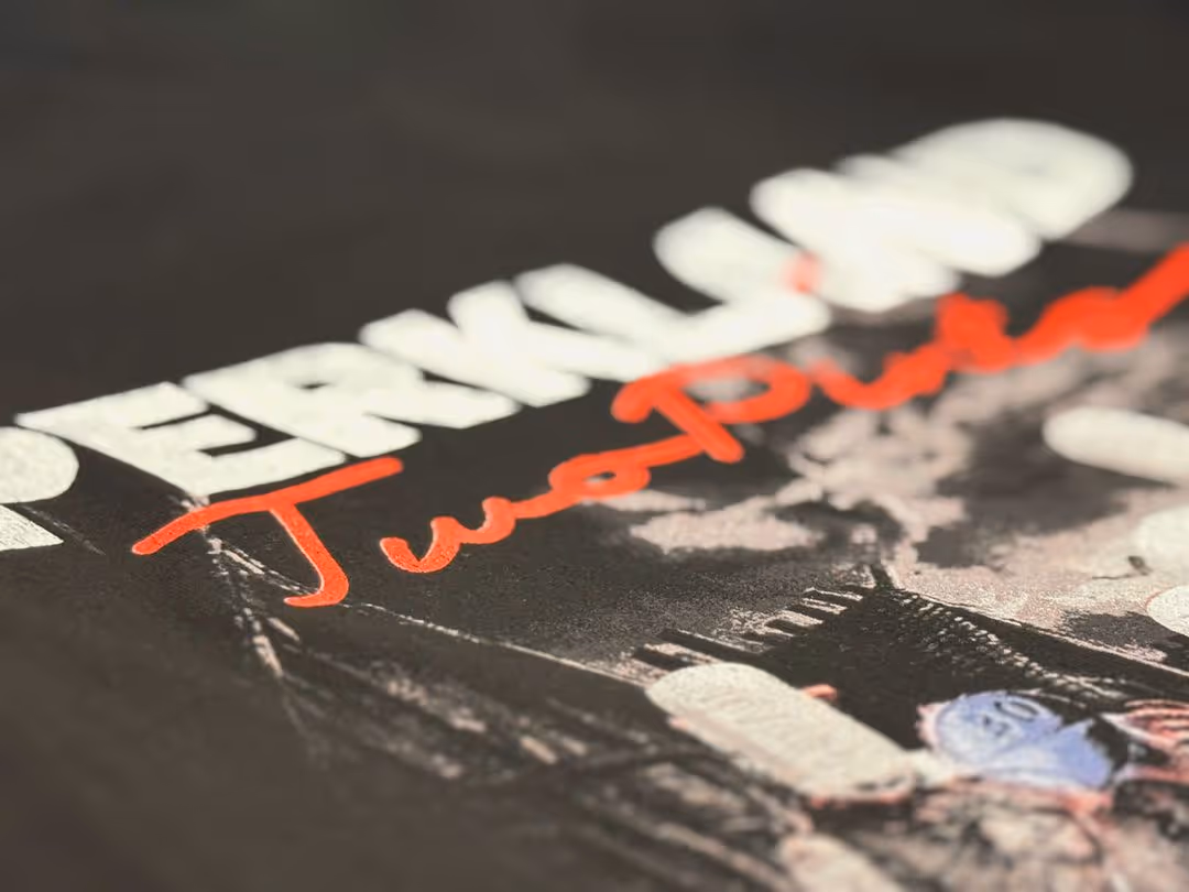 Close-up of a T-shirt with the words 'Twerk Team' in white and 'TwoPow' in red script.