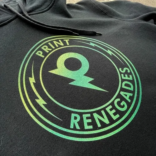 Close-up of black hoodie with circular Print Renegades logo in green gradient and lightning bolt design.