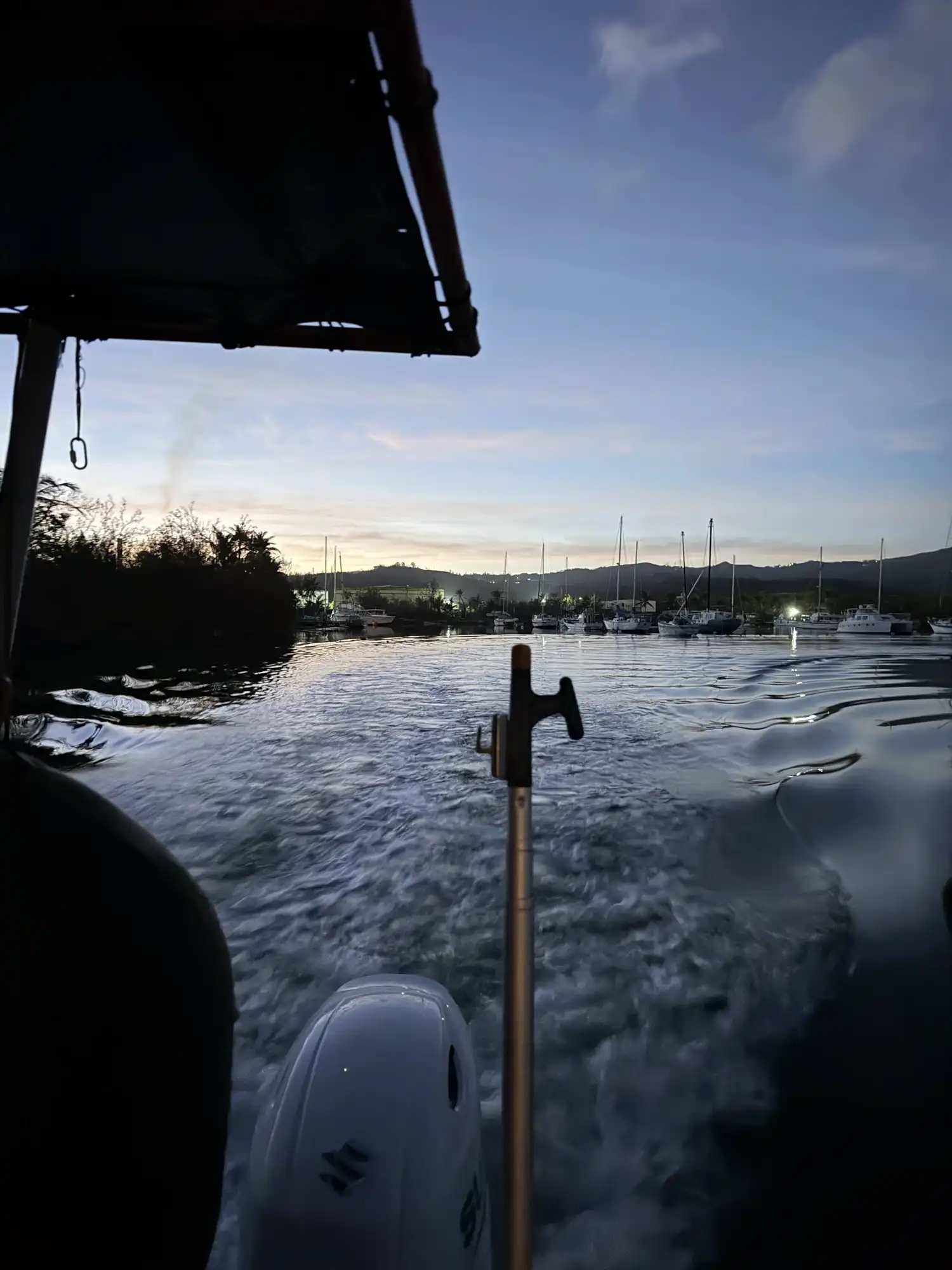 A research vessel motor leaves a wake while transiting out of a marina at dawn or dusk during the GAO Pacific Mission in Guam.