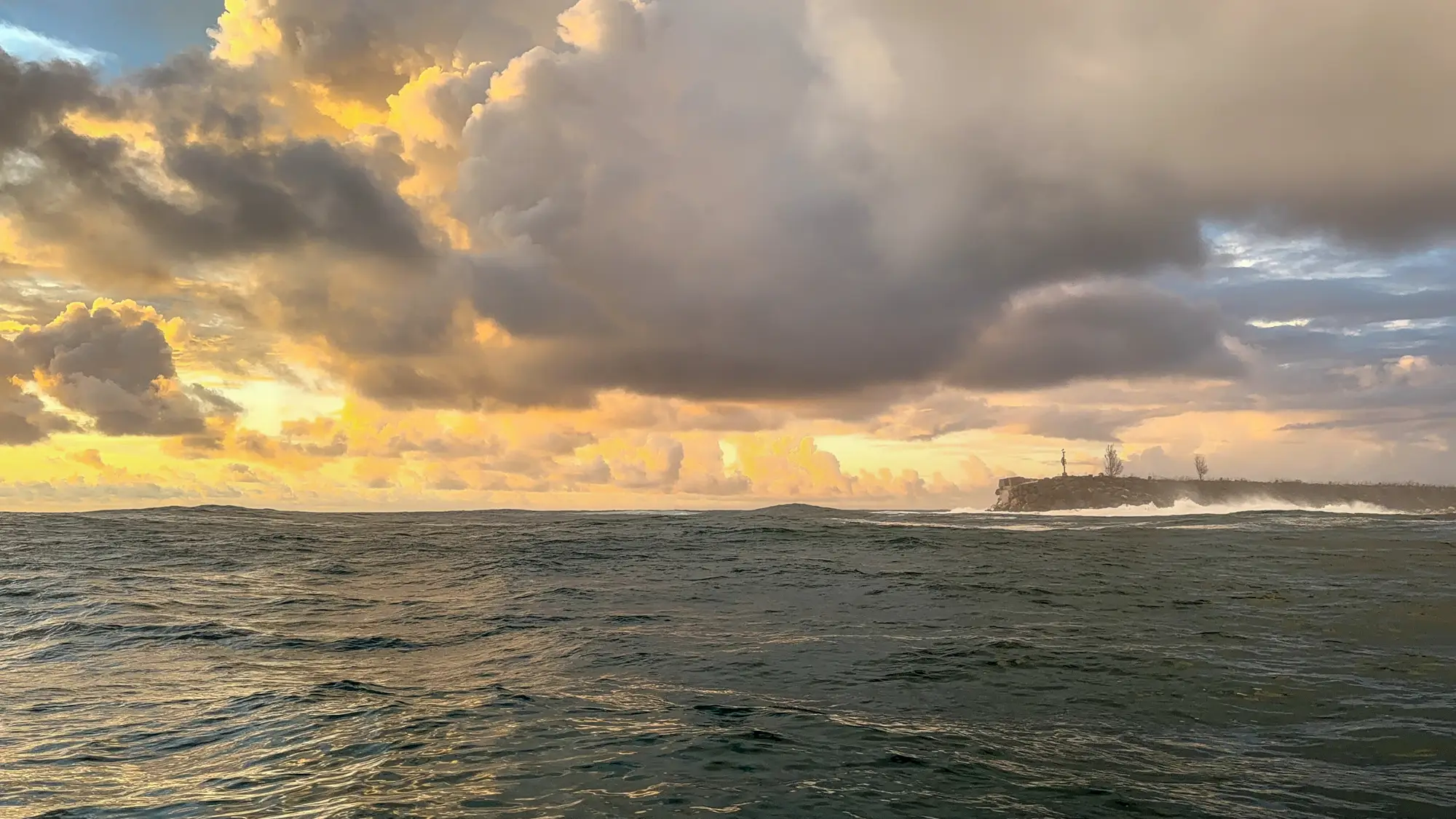 Heavy seas and dark storm clouds over the ocean near Guam's coastline during the GAO Pacific Mission.