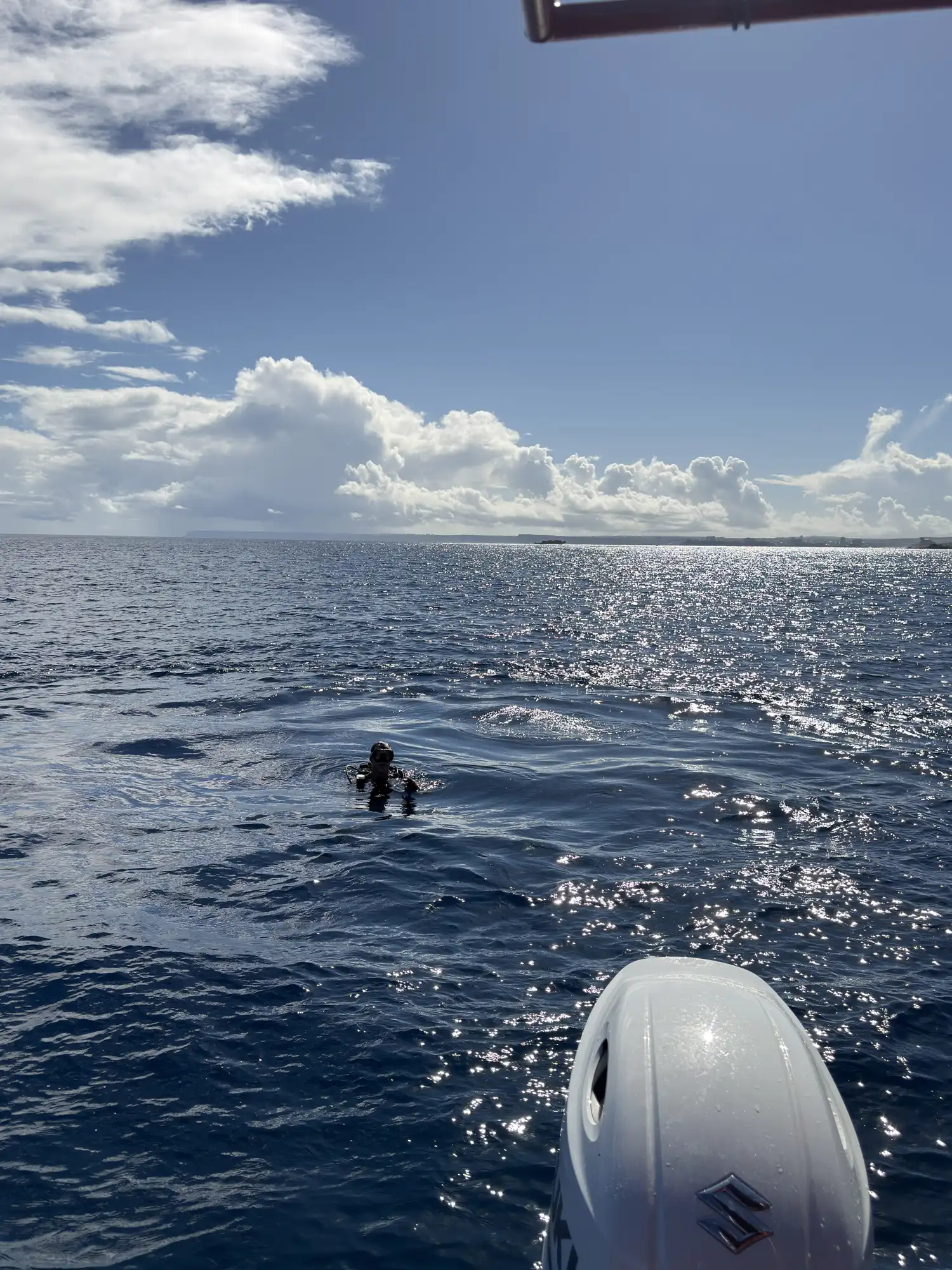 Hawaiʻi MERC diver surfacing in open ocean waters off Guam, viewed from the research vessel.