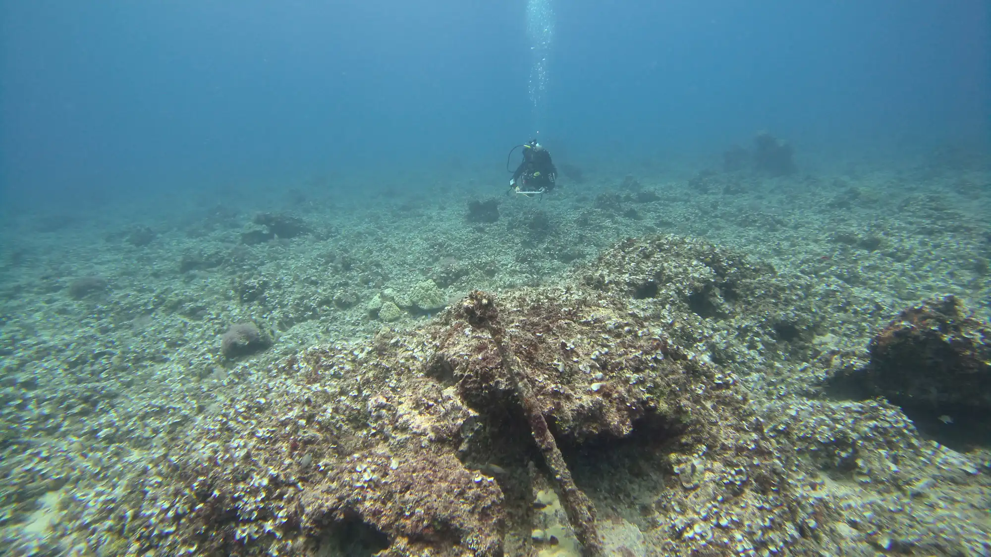 Hawaiʻi MERC diver conducting ground-truth mapping over an encrusted WWII artifact on a Guam coral reef.