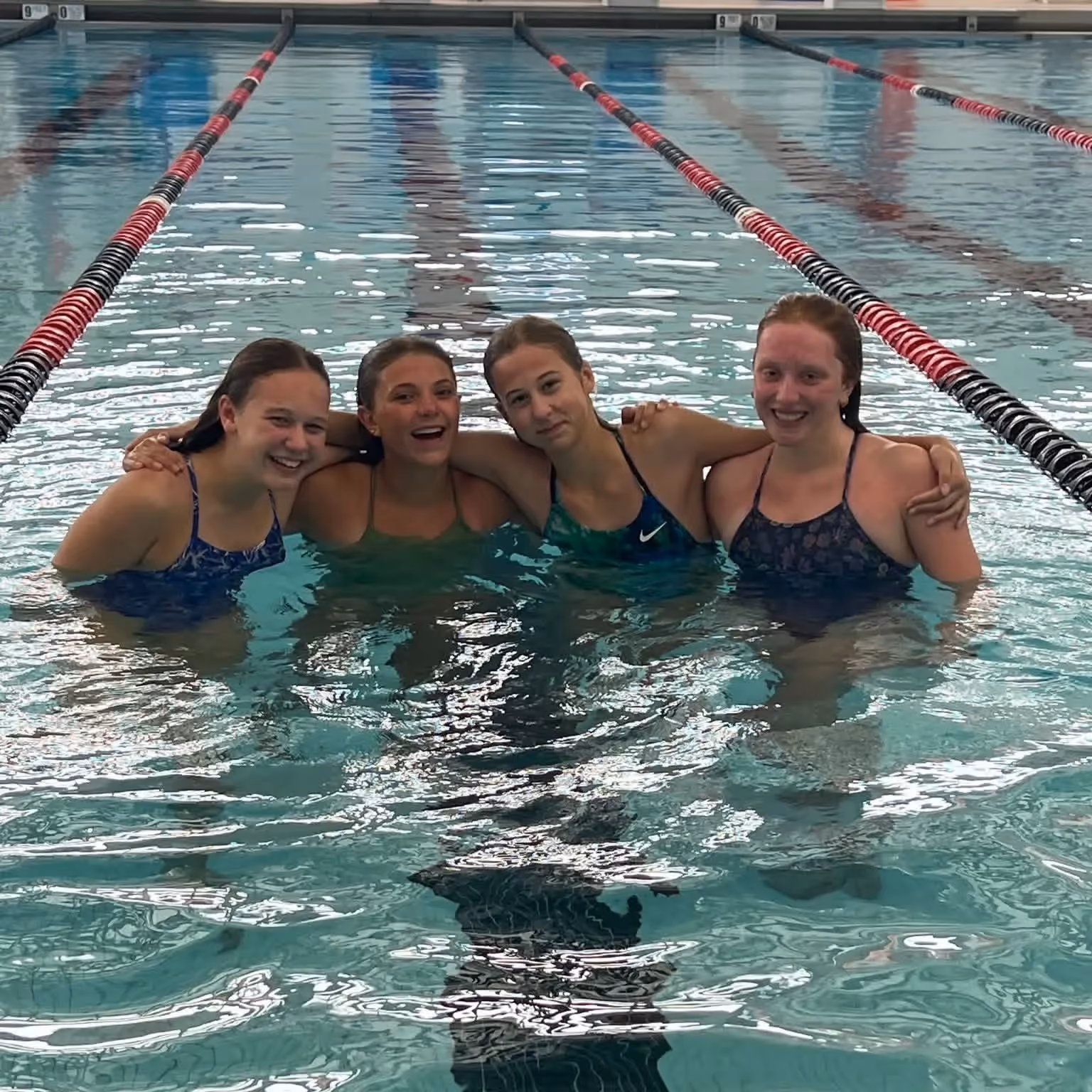 Hilton Area Swim Team meeting poolside organizing schedules and volunteers using Commit Swimming