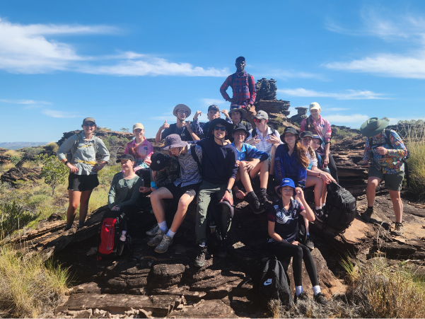 Group of students sitting on a boulder in the Kimberley's as part of the inaugural JSR Kimberley service learning team
