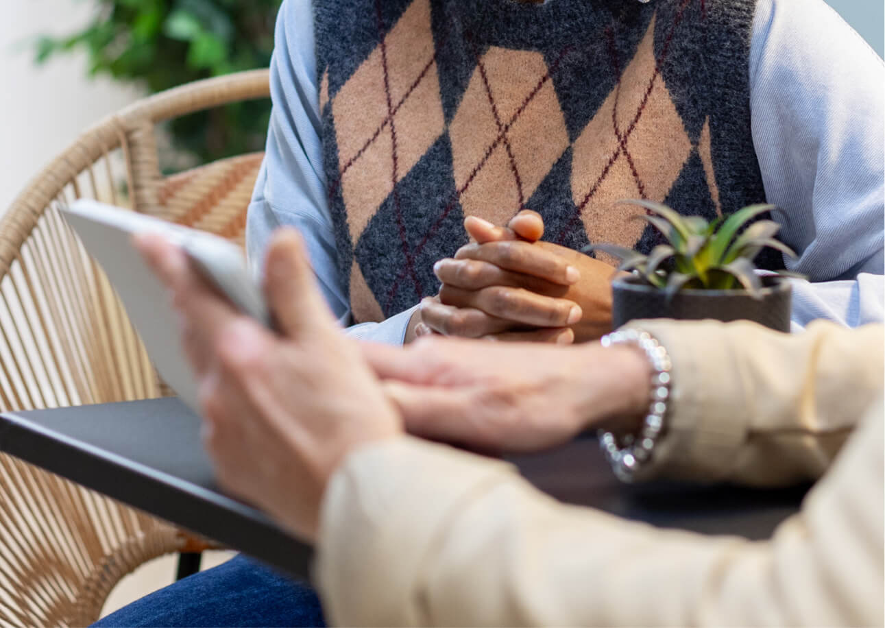 2 women sitting at a table discussing valuable information on an ipad