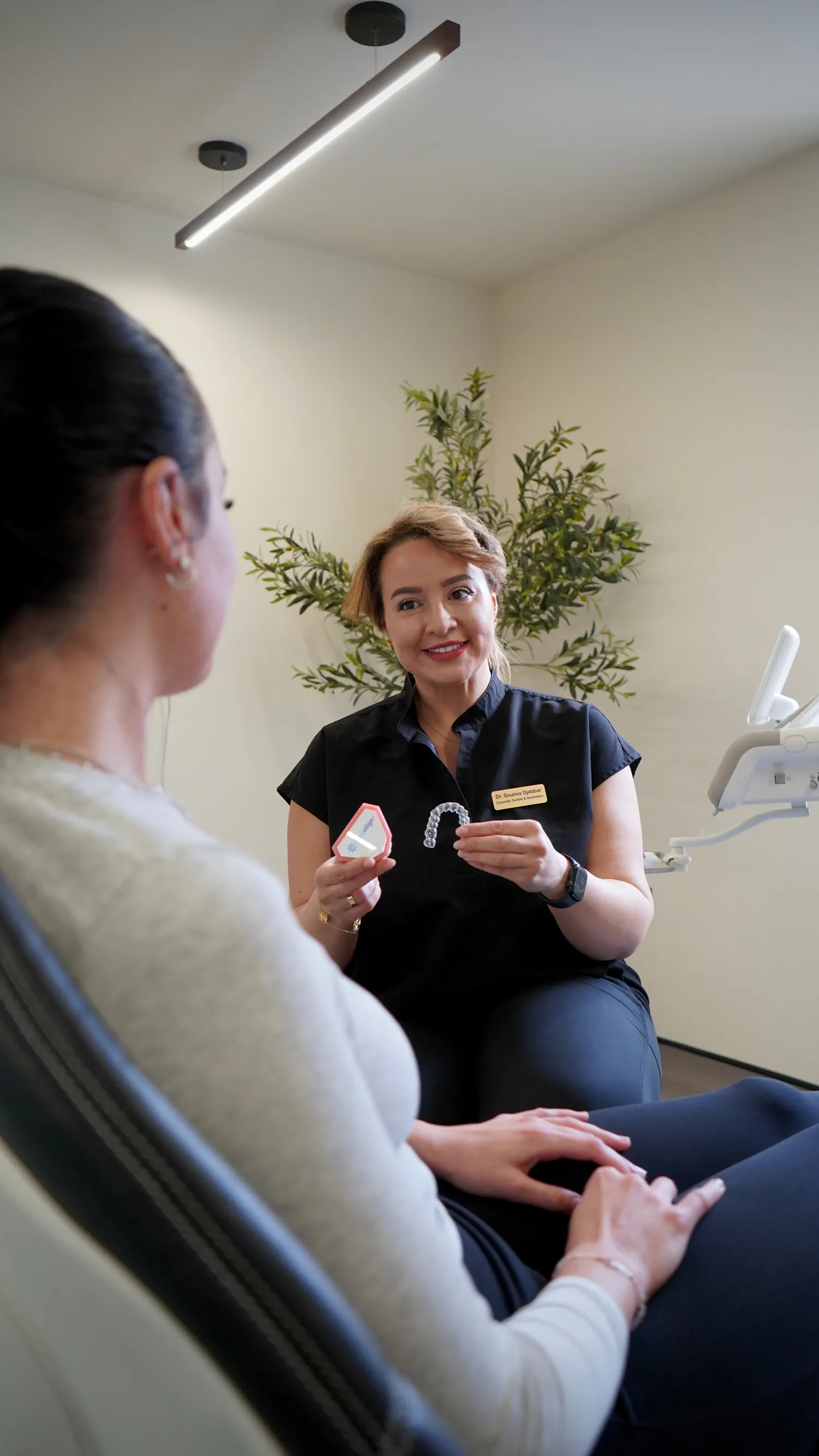 Dental professional explaining clear aligners to a patient in a dental office.