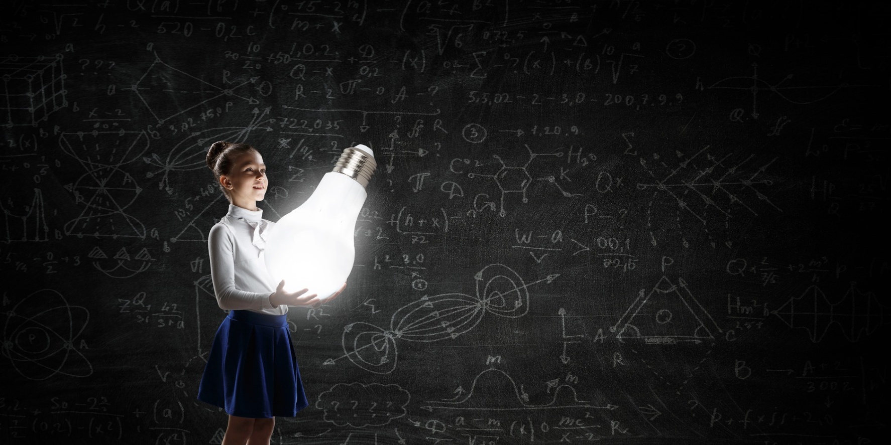 Student holding a glowing light bulb in a classroom representing education audio visual technology