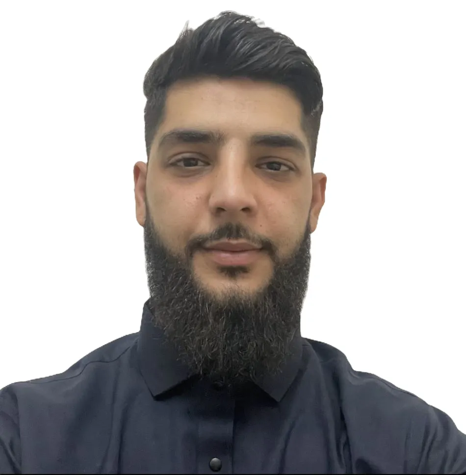 Man with neatly styled hair and full beard wearing a dark buttoned shirt against a white background.