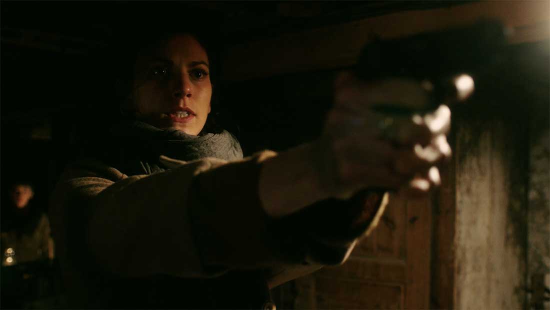 A woman holding a gun out.