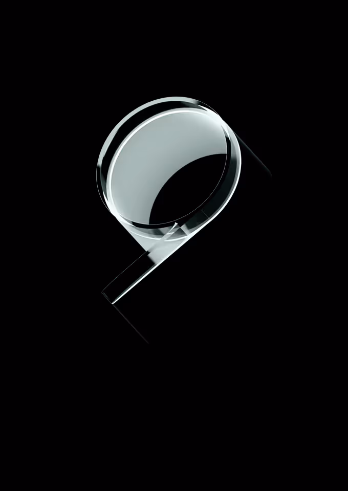 Transparent glass sculpture shaped like an abstract magnifying glass on a black background.