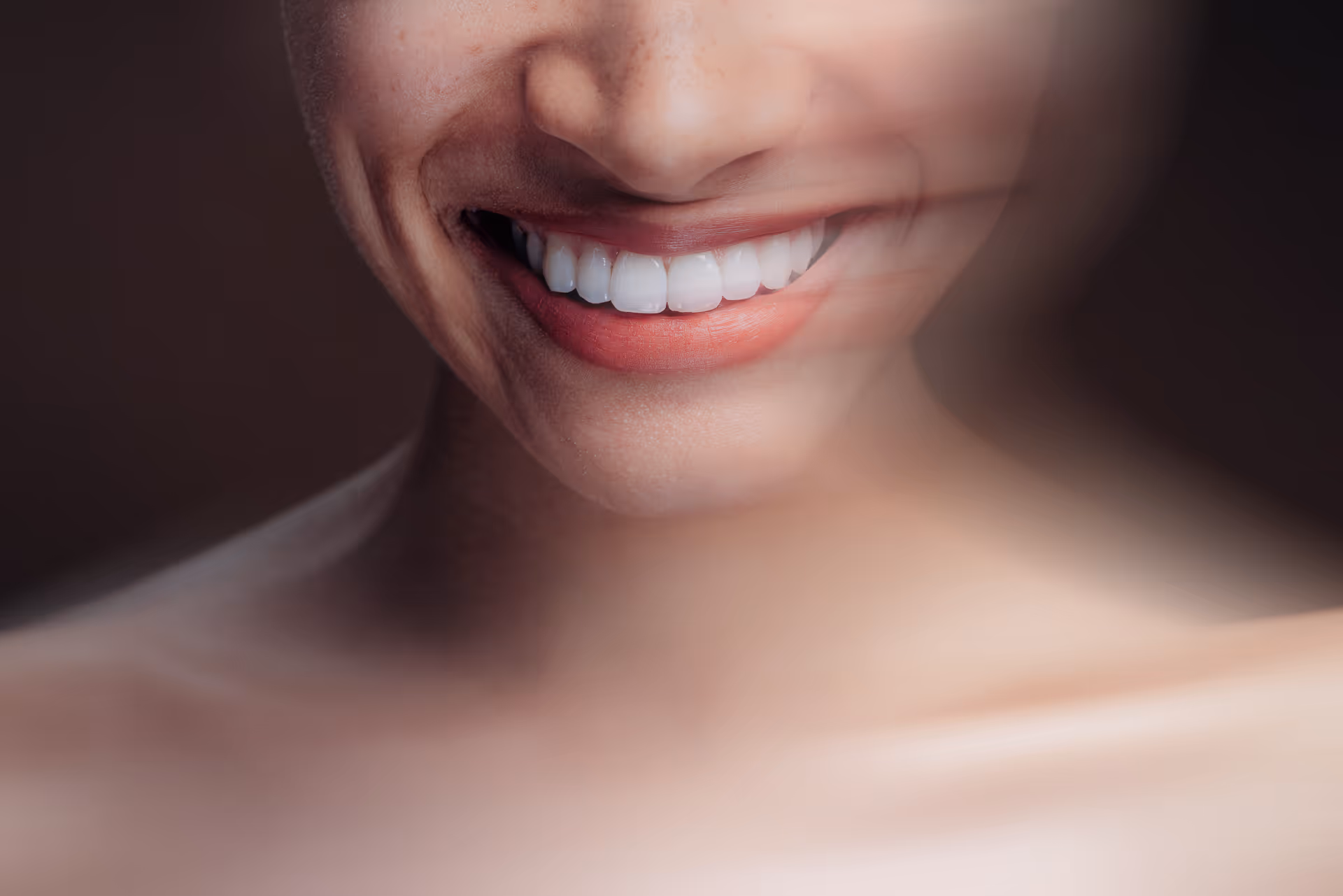 Nahaufnahme eines lächelnden Munds mit weißen Zähnen und rotem Lippenstift, verschwommene Bewegung rechts